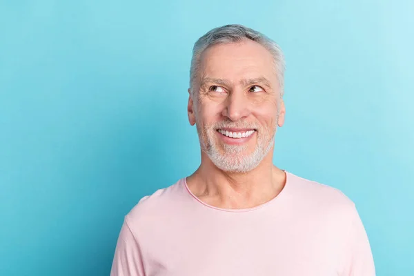 Foto porträtt leende man i rosa t-shirt ser copyspace isolerad på pastell blå färg bakgrund — Stockfoto