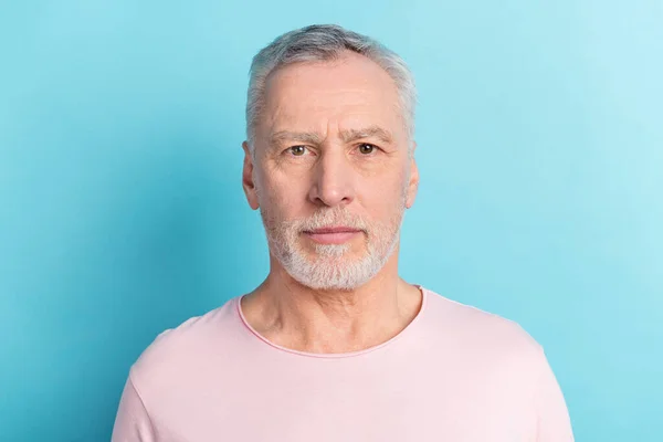 Photo portrait of serious bearded man in pink t-shirt isolated on pastel blue color background — Stock Photo, Image