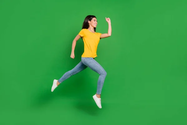Foto lateral de perfil de tamaño completo de la encantadora mujer bastante joven saltar correr espacio vacío aislado en el fondo de color verde — Foto de Stock