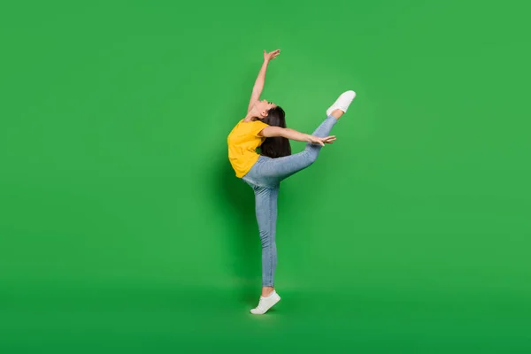 Foto de tamaño completo de alegre mujer joven agradable saltar bailarina de ballet buen humor aislado sobre fondo de color verde — Foto de Stock