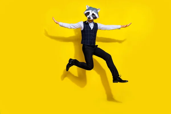Foto de surrealista absurdo auténtico chico máscara de mapache salto volar brazos aislados sobre amarillo brillante color fondo —  Fotos de Stock
