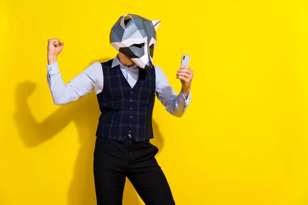 Zdjęcie utytułowanego faceta trzymać telefon pozytywna reakcja nosić szop maska kamizelka odizolowany żółty kolor tło — Zdjęcie stockowe