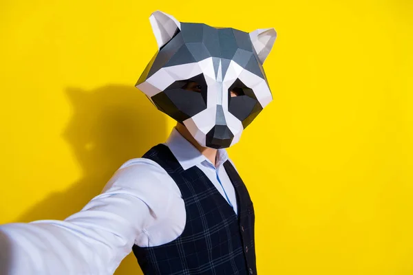 Photo of confident influencer guy hold camera take selfie wear raccoon mask vest isolated yellow color background — Stock Photo, Image