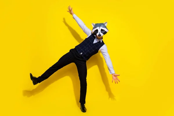 Foto av positiv anställd njuta halloween part dans bära tvättbjörn polygonal mask väst isolerad gul färg bakgrund — Stockfoto