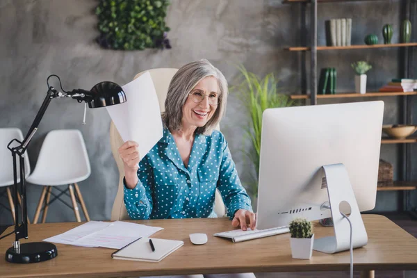 Porträtt av attraktiv glad äldre kvinna skapa kontraktspresentation på kontoret arbetsplatsen plats inomhus — Stockfoto