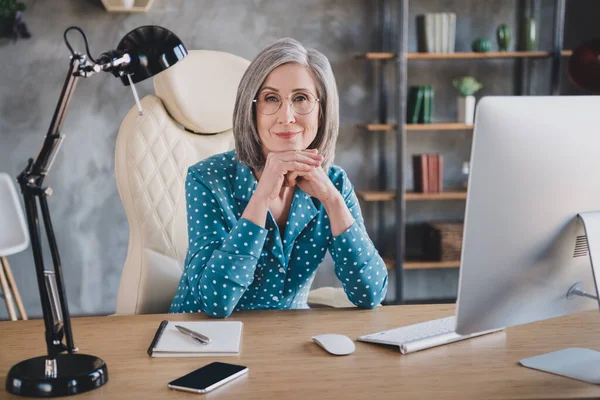 穏やかな穏やかな老婦人の写真は、オフィスの職場内で室内で働く眼鏡ビジネス女性を着用デスクに座る — ストック写真