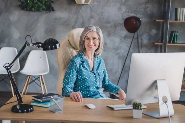 正の幸せな老婦人の写真は、オフィスの職場内室内のテーブルウェア眼鏡ビジネス女性座って — ストック写真