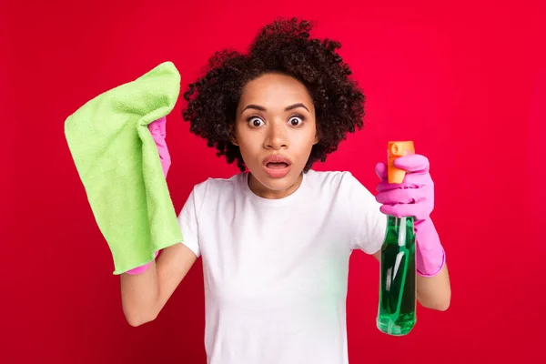 Фотопортрет домохозяйка изумлен носить перчатки полировка пыли изолированы яркий красный цвет фона — стоковое фото