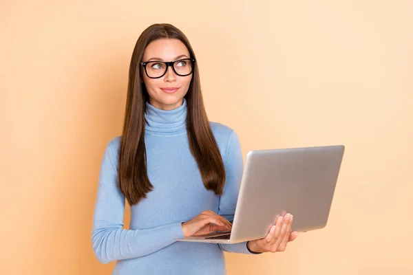 Foto de la joven morena inteligente tipo laptop look promo desgaste gafas suéter azul aislado sobre fondo de color beige —  Fotos de Stock