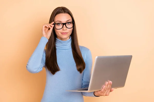 Foto di ceo bruna giovane signora tenere laptop indossare occhiali blu dolcevita isolato su sfondo di colore beige — Foto Stock