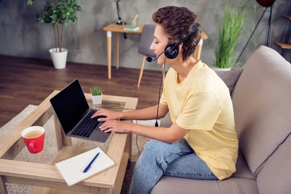 Foto van charmante dame zitten laptop lege ruimte werk dragen headset geel t-shirt in modern huis binnenshuis — Stockfoto