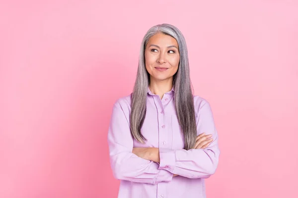 Portret van aantrekkelijke vrolijke grijs-harige vrouw dragen denken kopieerruimte gevouwen armen geïsoleerd over roze pastel kleur achtergrond — Stockfoto