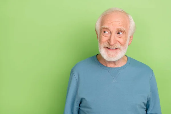 Φωτογραφία από αστεία παλιά γενειάδα άνθρωπος εξετάσουμε κενό χώρο φορούν μπλε πουλόβερ που απομονώνονται σε πράσινο φόντο χρώμα — Φωτογραφία Αρχείου