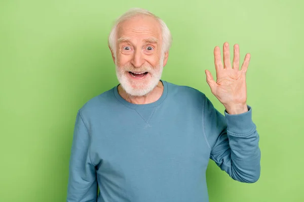 Etkilenmiş yaşlı sakallı adamın fotoğrafı yeşil arka planda mavi süveter giyiyor. — Stok fotoğraf