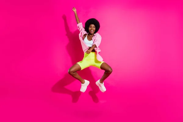 Foto em tamanho completo de jovem menina negra feliz sorriso positivo saltar reide cavalo rodeio oeste selvagem isolado sobre cor rosa fundo — Fotografia de Stock