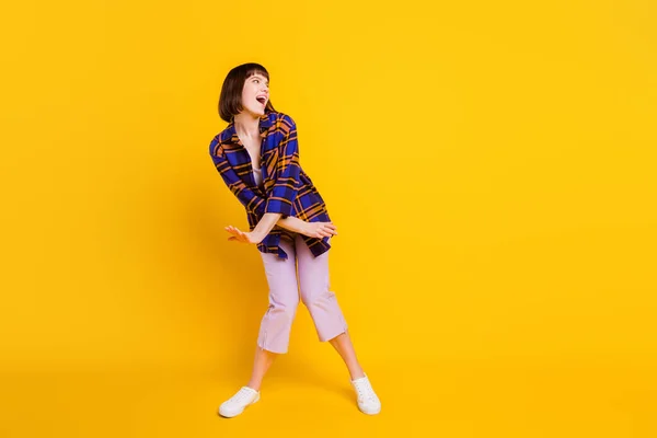 Tam boy vücut ölçülerinde dans eden neşeli bir kızın parlak sarı arka planda izole edilmiş eğlencesinin görüntüsü. — Stok fotoğraf