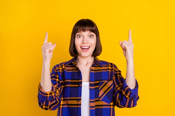 Portrait of pretty cheerful amazed girl demonstrating up copy space ad idea isolated over bright yellow color background — Stock Photo, Image