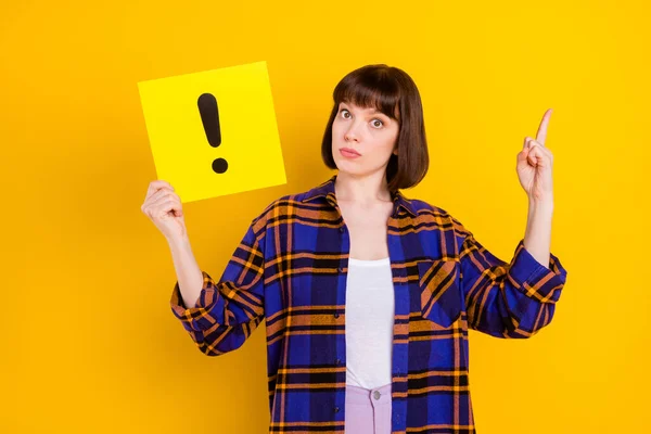 Portrét atraktivní dívky držící kartu informační panel ukazující nahoru izolované přes jasně žluté barvy pozadí — Stock fotografie