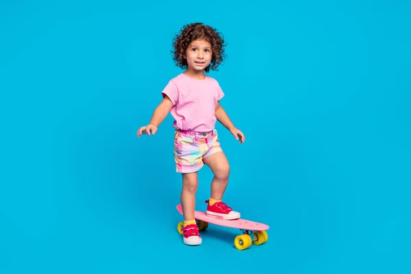 Comprimento total tamanho do corpo vista de menina alegre atraente andar de skate se divertindo isolado sobre fundo de cor azul brilhante — Fotografia de Stock