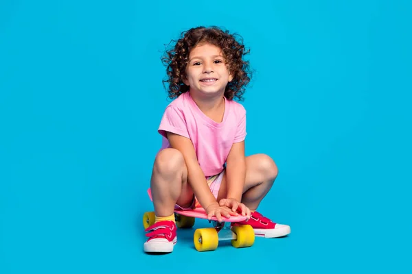 stock image Portrait of attractive cheerful wavy-haired girl riding skate pastime isolated over bright blue color background