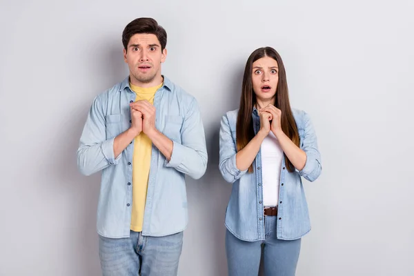 Photo of scared frightened sister brother wear jeans shirts hearing bad news isolated grey color background