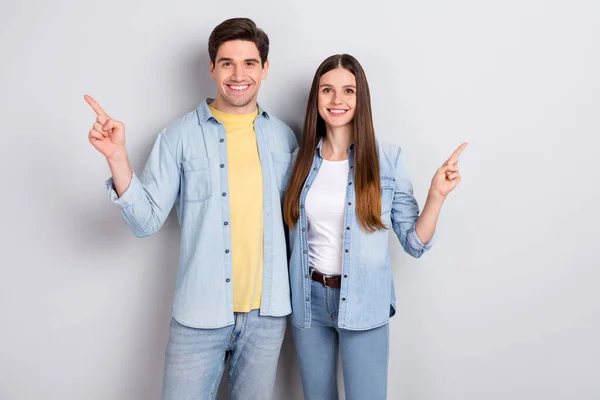 Photo of sweet charming sister brother wear jeans shirts hugging pointing empty space isolated grey color background — Stock Photo, Image