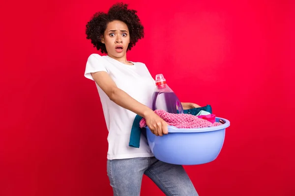 Foto retrato ama de casa sorprendido mantener tazón de ropa sucia hacer limpieza aislado vibrante fondo de color rojo — Foto de Stock