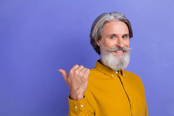 Profile side photo of cheerful mature man point finger empty space recommend direct banner isolated over violet color background — Stock Photo, Image