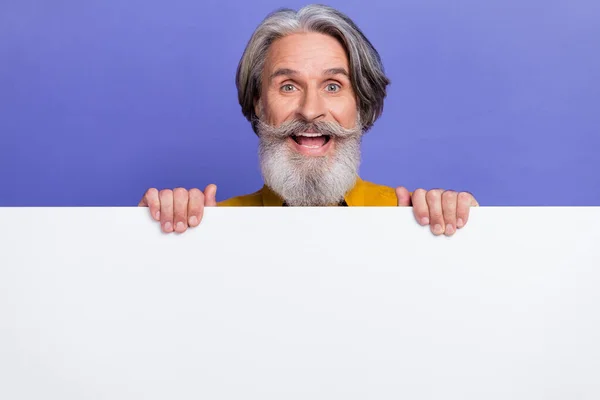Portrait d'homme attrayant aux cheveux gris joyeux montrant copie espace vide ad isolé sur fond violet vif couleur pourpre — Photo
