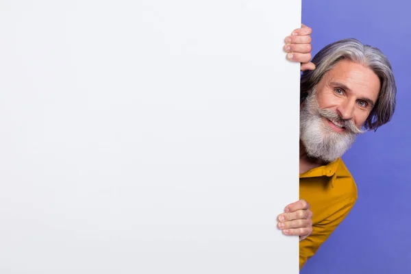 Portret van aantrekkelijke vrolijke grijs-harige man houden kopie lege ruimte ad geïsoleerd over heldere paarse kleur achtergrond — Stockfoto