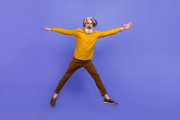 Pleine longueur vue de la taille du corps de joyeux homme drôle aux cheveux gris sautant avoir du plaisir isolé sur fond violet vif de couleur pourpre — Photo