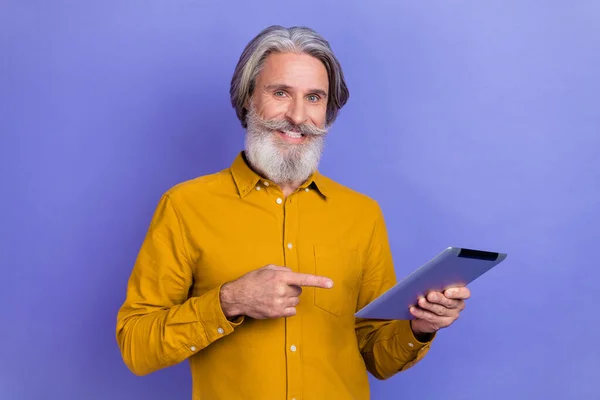 Retrato de homem de cabelos grisalhos alegre atraente usando tablet demonstrando isolado sobre fundo de cor violeta violeta brilhante — Fotografia de Stock