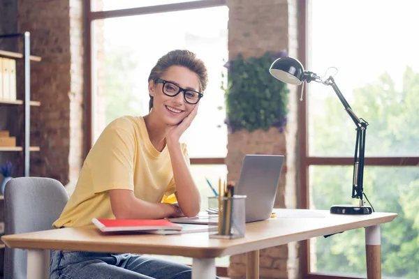 Foto van tevreden mooie jonge vrouw gekleed geel t-shirt werken modern apparaat glimlachen binnen huiskamer — Stockfoto