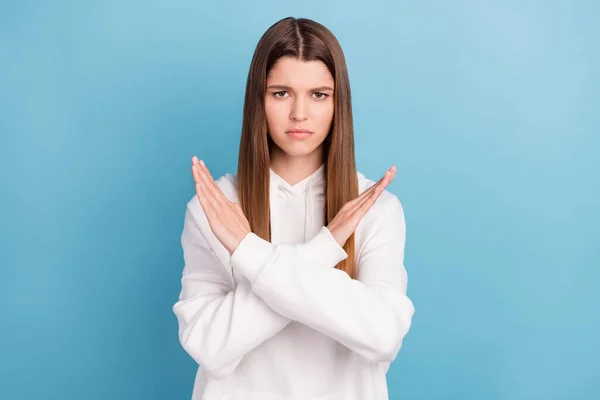 Foto retrato menina em branco encapuzado infeliz com as mãos cruzadas mostrando parar isolado pastel azul cor de fundo — Fotografia de Stock