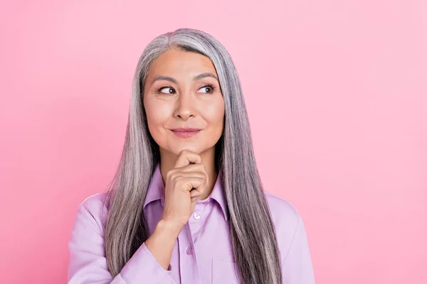 Portret van aantrekkelijke vrolijke nieuwsgierig grijs-harige vrouw overdenken kopieerruimte geïsoleerd over roze pastel kleur achtergrond — Stockfoto