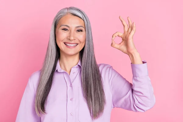 Ritratto di attraente donna dai capelli grigi allegra che mostra soluzione pubblicitaria ok-segno isolato su sfondo rosa pastello — Foto Stock