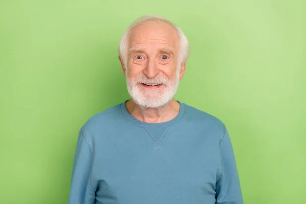 Фотографія оптимістичного старого бородатого чоловіка в синьому светрі ізольовано на зеленому кольоровому фоні — стокове фото