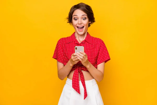 Foto de pessoa positiva surpreso boca aberta olhar telefone novo comentário siga isolado no fundo de cor amarela — Fotografia de Stock