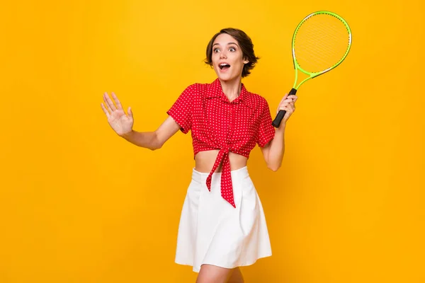Kuva optimistinen mukava brunette nainen pelata tennis kulumista paita hame eristetty keltainen väri tausta — kuvapankkivalokuva