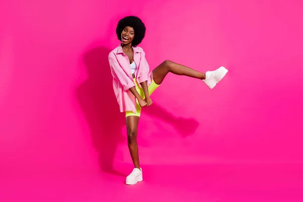 Fénykép funky imádnivaló sötét bőr nő öltözött termés top mosolygós tánc elszigetelt rózsaszín szín háttér — Stock Fotó
