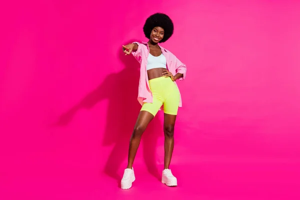 Photo of adorable pretty dark skin woman dressed crop top smiling dancing pointing finger you isolated pink color background — Stock Photo, Image