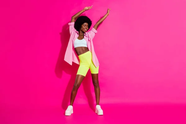 Photo of cute shiny dark skin lady wear casual shirt dancing smiling isolated pink color background — Stock Photo, Image
