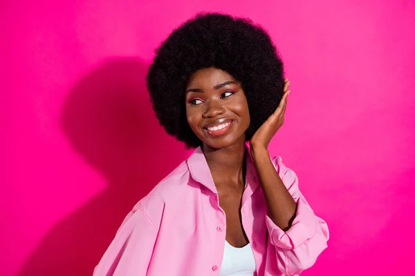 Photo of sweet charming dark skin kobieta ubrana górę uśmieszki fryzura ramię patrząc puste miejsce odizolowane różowy kolor tło — Zdjęcie stockowe