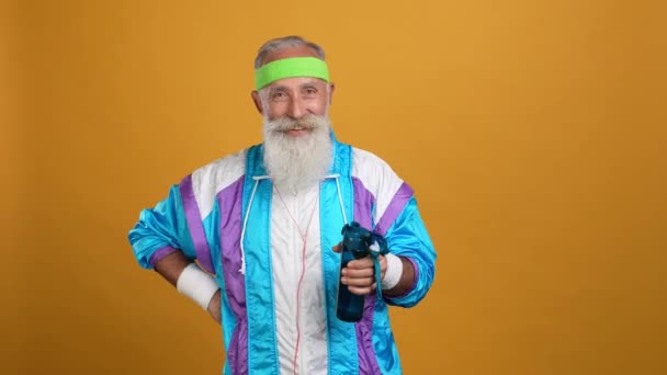 El hombre jubilado tren fuerte recomienda beber agua aislado color brillante fondo — Vídeos de Stock