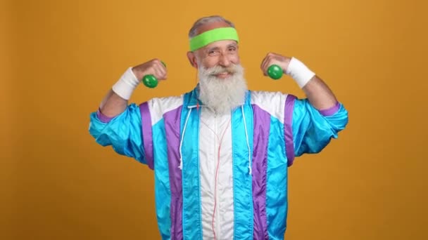 Gepensioneerde man stijlvolle trendy trainer power lift geïsoleerde levendige kleur achtergrond — Stockvideo