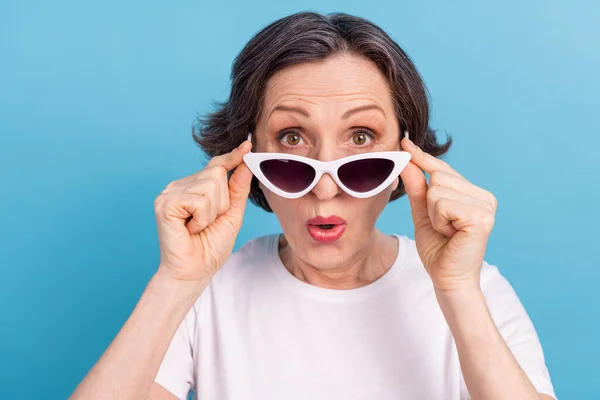 Portrait of atraktif amazed woman wearing touching specs news sale reaction isolated over bright blue color background — Stok Foto
