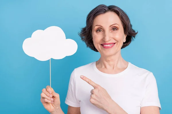 Photo portrait senior woman smiling pointing white cloud with copyspace on stick isolated pastel blue color background — 图库照片