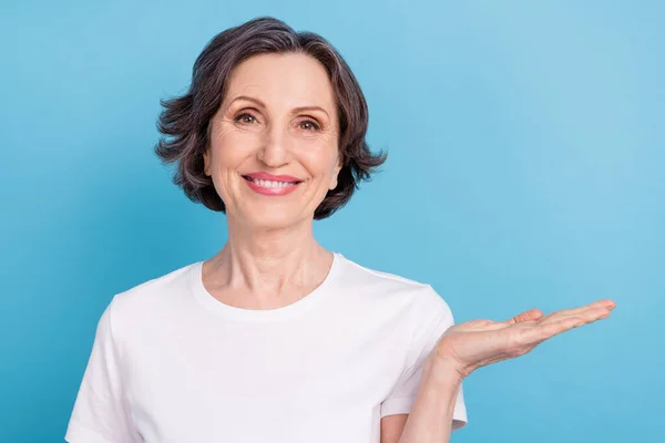 Foto mulher retrato mantendo espaço em branco na palma sorrindo isolado pastel azul cor fundo — Fotografia de Stock