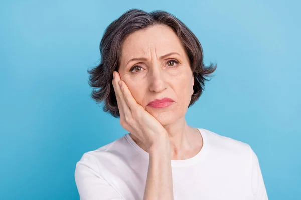 Портрет привлекательной депрессивной седой женщины, страдающей зубной болью на ярко-голубом фоне — стоковое фото