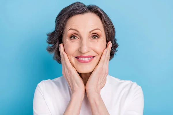 Foto retrato sonriente mujer tocando mejilla usando ropa blanca aislado pastel color azul fondo — Foto de Stock